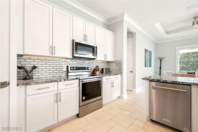101 Bald Eagle Dr, Marco Island, FL 34145 - kitchen featuring stainless steel appliances, backsplash, white cabinetry, dark stone counters, and crown molding