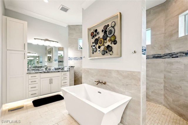 bathroom featuring independent shower and bath, vanity, tile walls, and ornamental molding