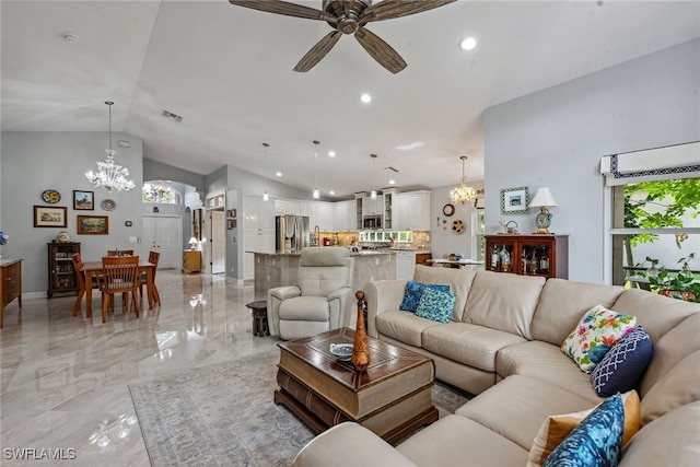 living room with ceiling fan with notable chandelier and vaulted ceiling