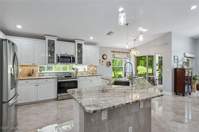 kitchen with a large island, sink, white cabinetry, hanging light fixtures, and stainless steel appliances