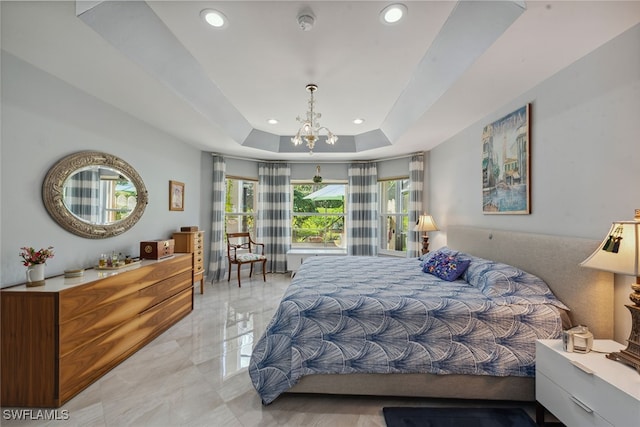 bedroom featuring a tray ceiling and a chandelier