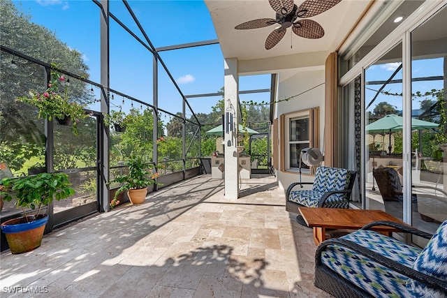 unfurnished sunroom featuring ceiling fan and a healthy amount of sunlight