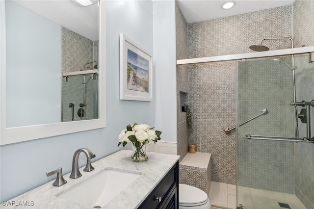 bathroom featuring vanity, toilet, and an enclosed shower