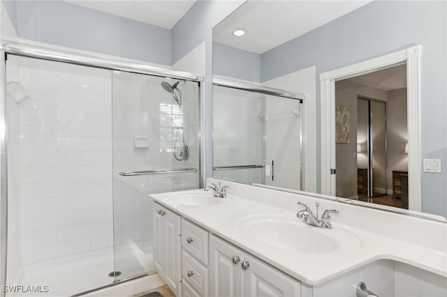 bathroom with a shower with shower door and vanity