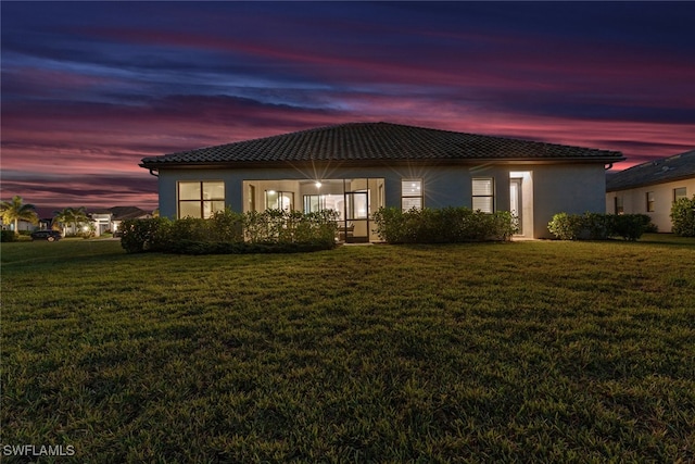 back house at dusk with a yard