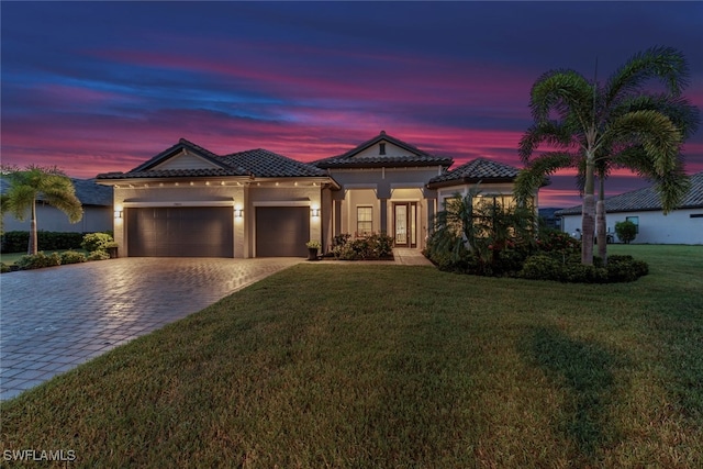 mediterranean / spanish-style home featuring a yard and a garage