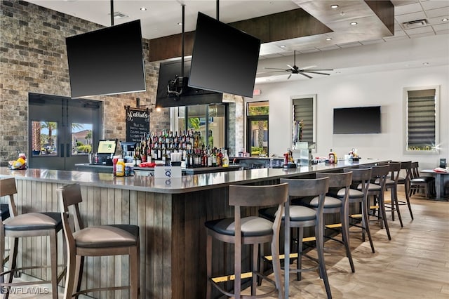 bar featuring light wood-type flooring and ceiling fan