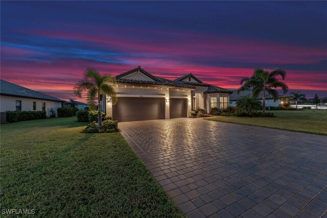 view of front of property with a yard and a garage