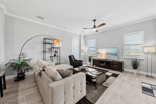 living room with crown molding, a healthy amount of sunlight, and ceiling fan