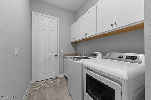 laundry room with cabinets, light wood-type flooring, and washing machine and clothes dryer