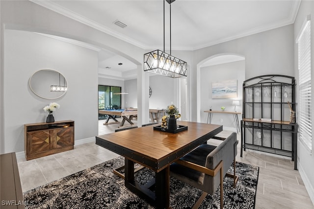 dining area featuring ornamental molding, light hardwood / wood-style flooring, and a chandelier