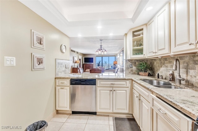 kitchen featuring dishwasher, sink, an inviting chandelier, light tile patterned floors, and light stone countertops