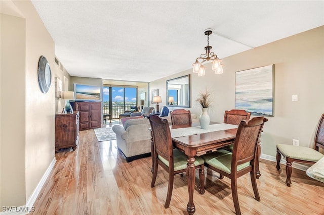 dining area featuring a notable chandelier and light hardwood / wood-style flooring