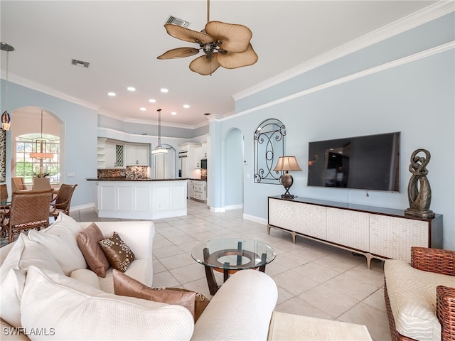 living room with light tile patterned flooring, ornamental molding, and ceiling fan