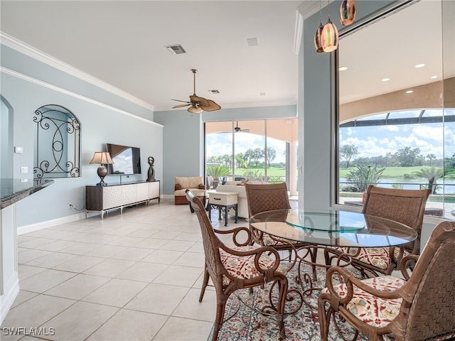 tiled dining area with a healthy amount of sunlight, crown molding, and ceiling fan