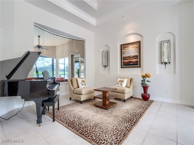 living area with crown molding, ceiling fan, and light tile patterned floors