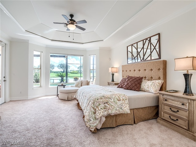 carpeted bedroom with ornamental molding, ceiling fan, and a raised ceiling