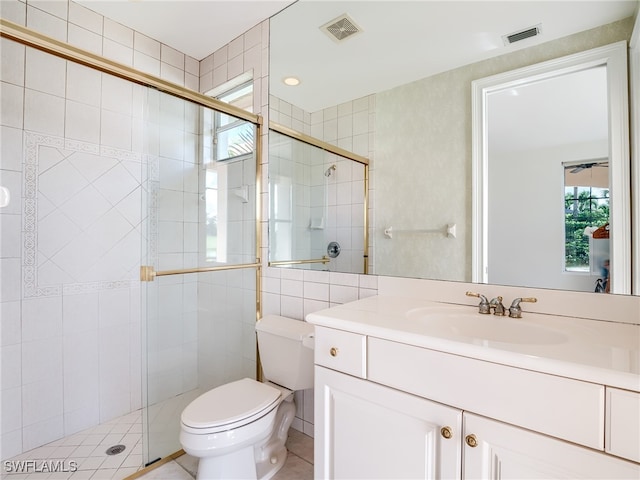 bathroom with vanity, tile patterned flooring, toilet, and an enclosed shower