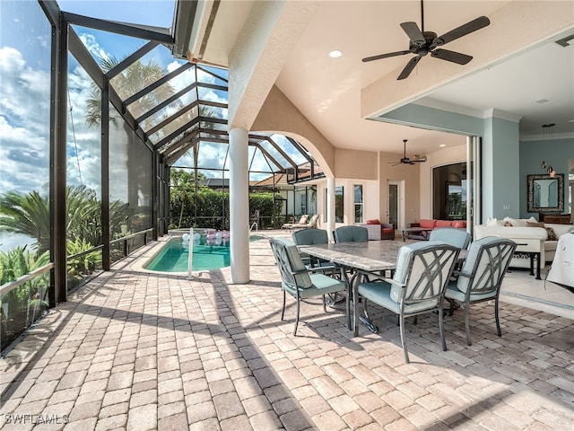 view of swimming pool with ceiling fan, glass enclosure, and a patio area