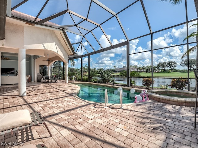 view of pool with glass enclosure, a patio, an in ground hot tub, a water view, and ceiling fan