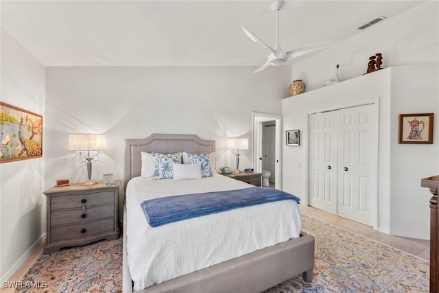 tiled bedroom featuring ceiling fan, a closet, and vaulted ceiling