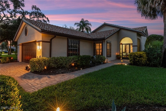 view of front of property with a garage and a yard