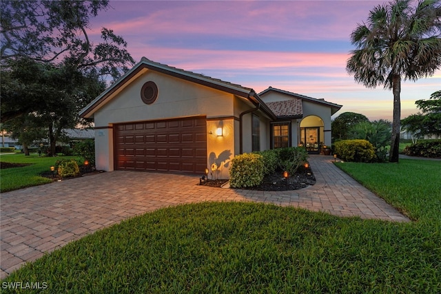 view of front of property featuring a lawn and a garage