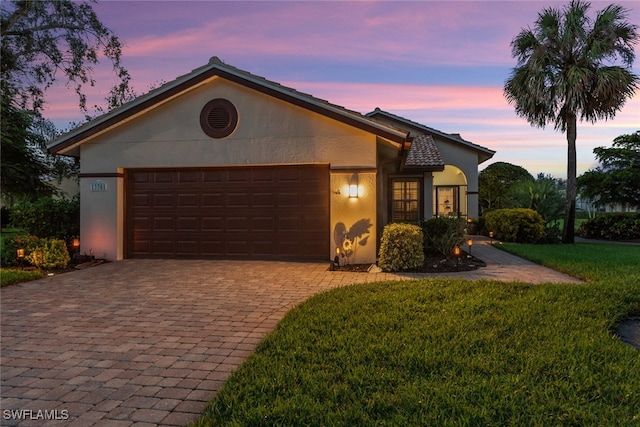 view of front of property featuring a lawn and a garage