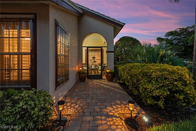 view of exterior entry at dusk