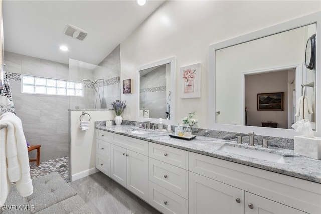 bathroom with vanity and a tile shower