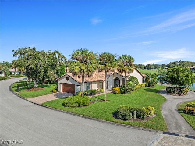 mediterranean / spanish house featuring a front lawn and a garage