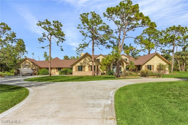 view of front of property with a front lawn and curved driveway