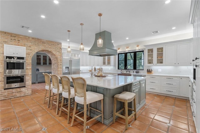 3628 Heritage Ln, Fort Myers, FL 33908 - kitchen with light countertops, stainless steel appliances, visible vents, and island range hood