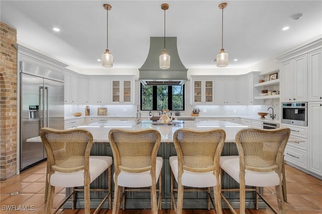 kitchen with premium range hood, glass insert cabinets, stainless steel appliances, and light countertops