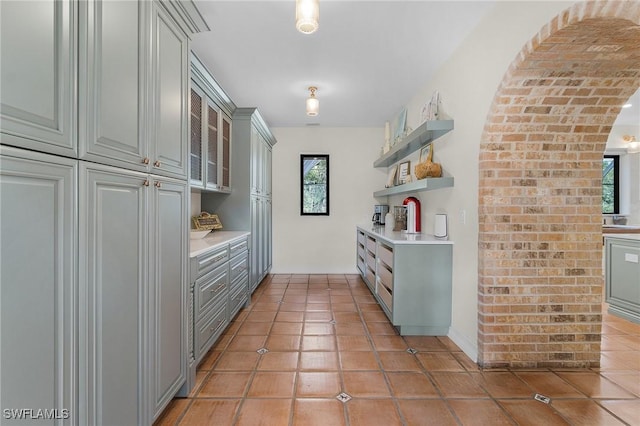 kitchen with gray cabinetry, plenty of natural light, and light tile patterned floors