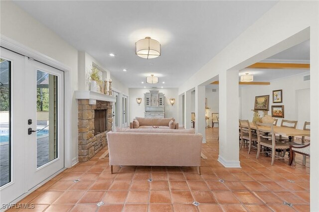 living room with a fireplace, light tile patterned floors, and french doors