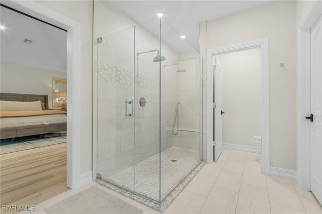 bathroom featuring tile patterned flooring, toilet, and walk in shower