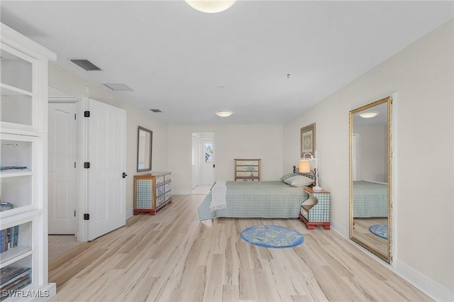 bedroom featuring light wood-type flooring, baseboards, and visible vents