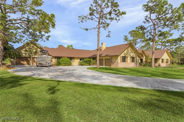 view of front of property featuring a garage, driveway, a chimney, and a front yard