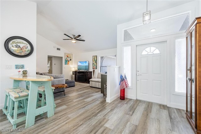 foyer entrance featuring ceiling fan, light hardwood / wood-style flooring, and vaulted ceiling