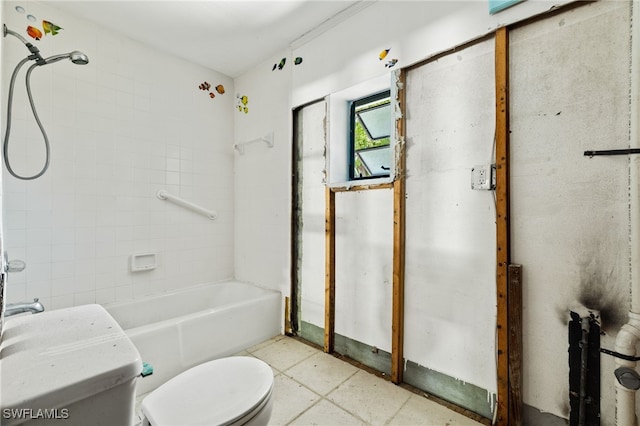 bathroom featuring tiled shower / bath combo and toilet