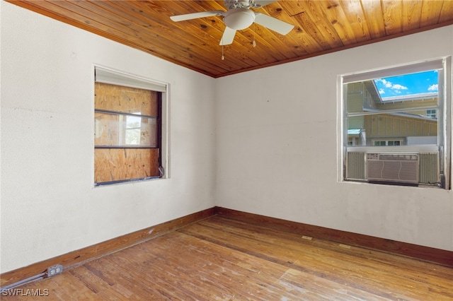 empty room featuring wood-type flooring, wood ceiling, ceiling fan, and a wealth of natural light