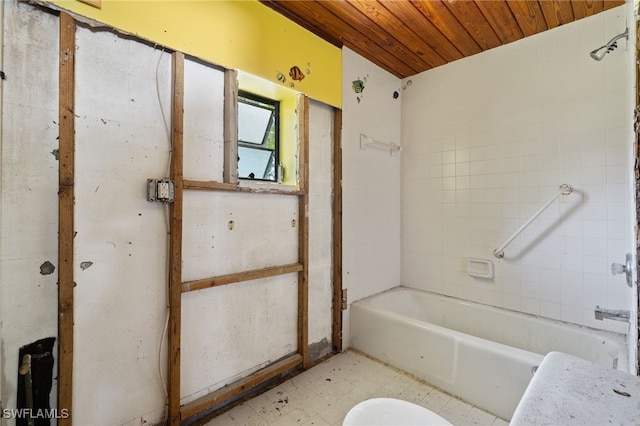 bathroom featuring wood ceiling, tiled shower / bath combo, and toilet