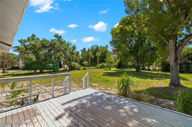 wooden deck featuring a lawn