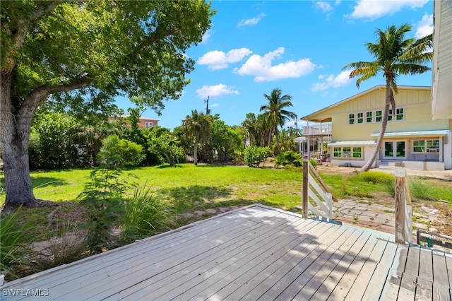 wooden deck featuring a lawn