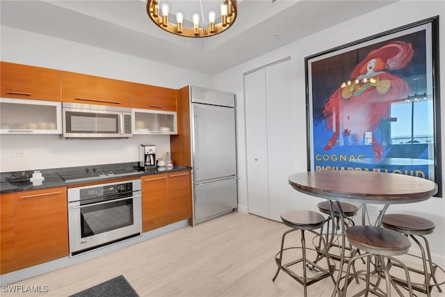 kitchen with a notable chandelier, stainless steel appliances, and light hardwood / wood-style floors