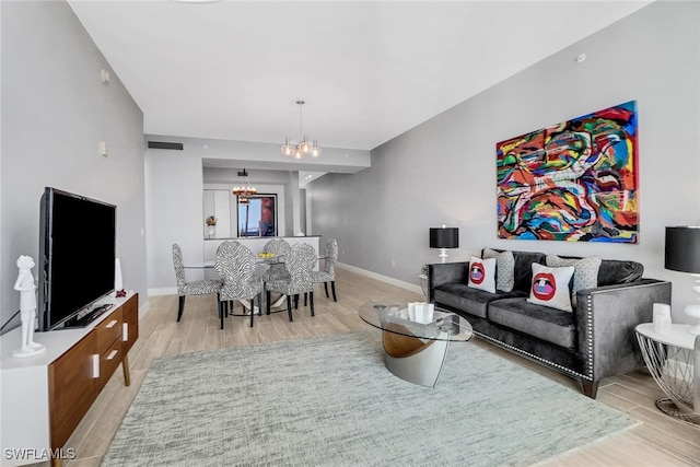 living room with a notable chandelier and light hardwood / wood-style floors