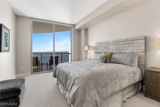 carpeted bedroom with access to exterior and a wall of windows