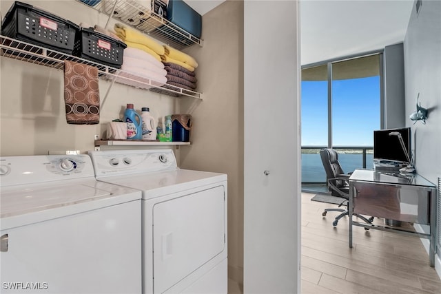 washroom with washer and clothes dryer and light wood-type flooring