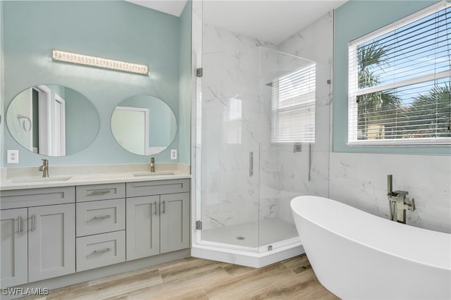 bathroom featuring vanity, plus walk in shower, tile walls, and hardwood / wood-style flooring